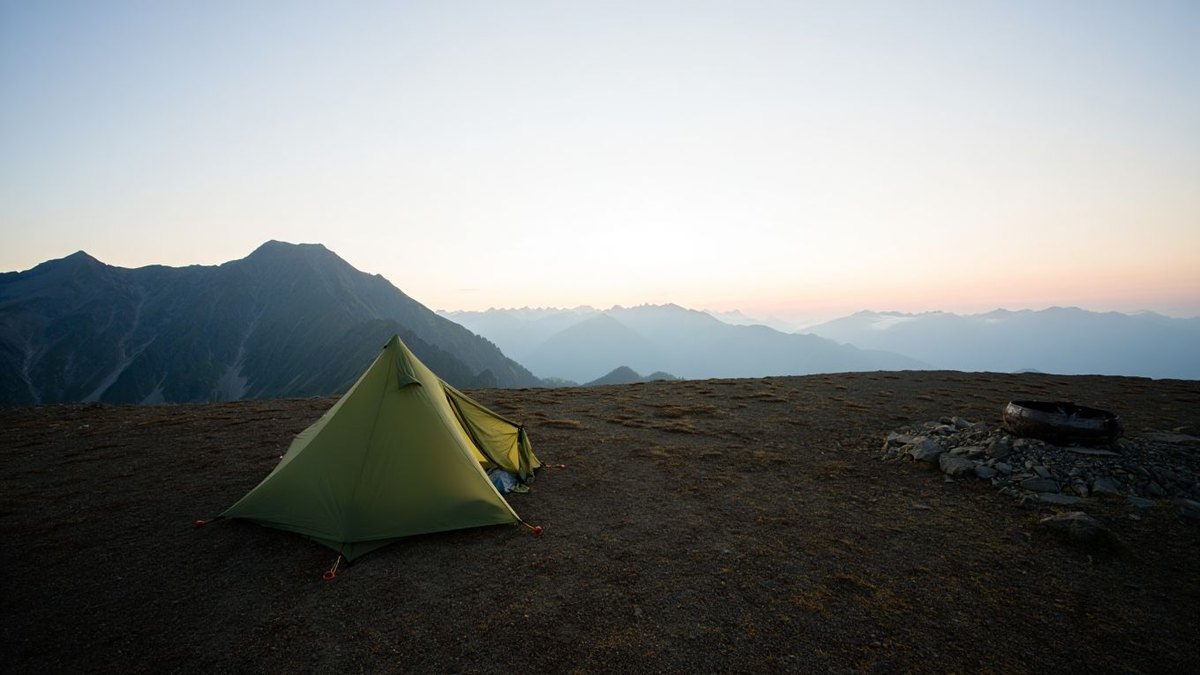 Tente discrète au lever du jour dans un paysage naturel sans feu sans texte ni marque