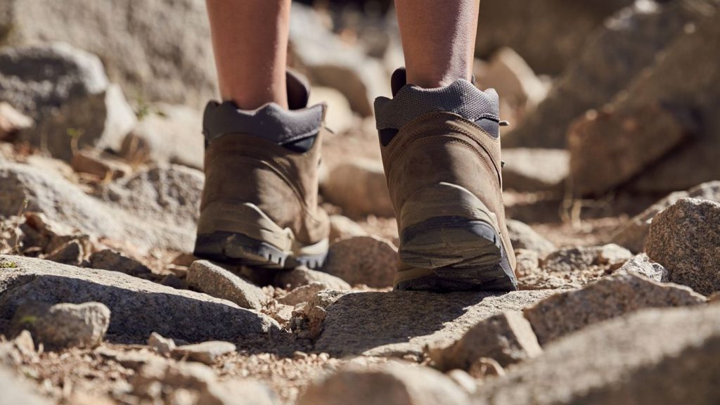 Chaussures de randonnée anonymes sur un sentier pierreux