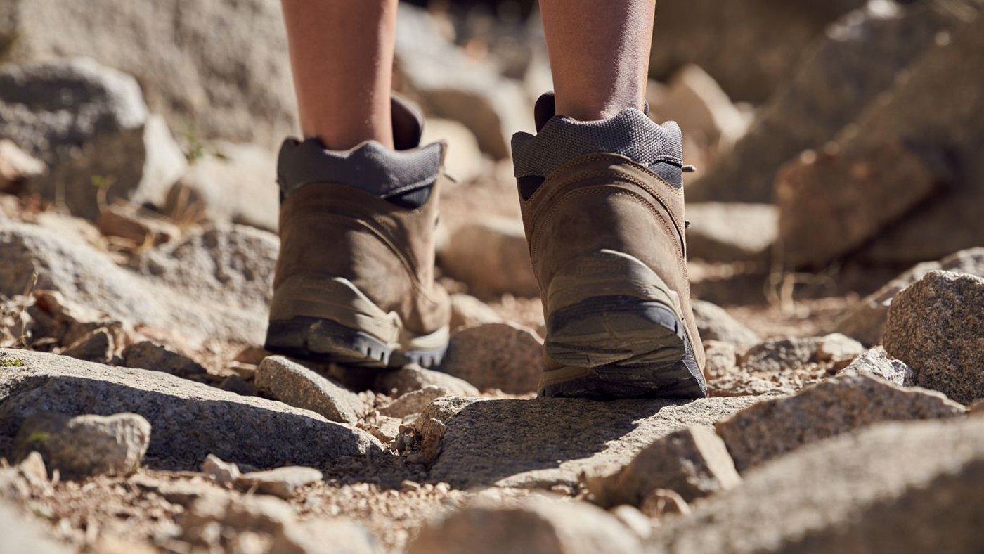 Chaussures de randonnée anonymes sur un sentier pierreux