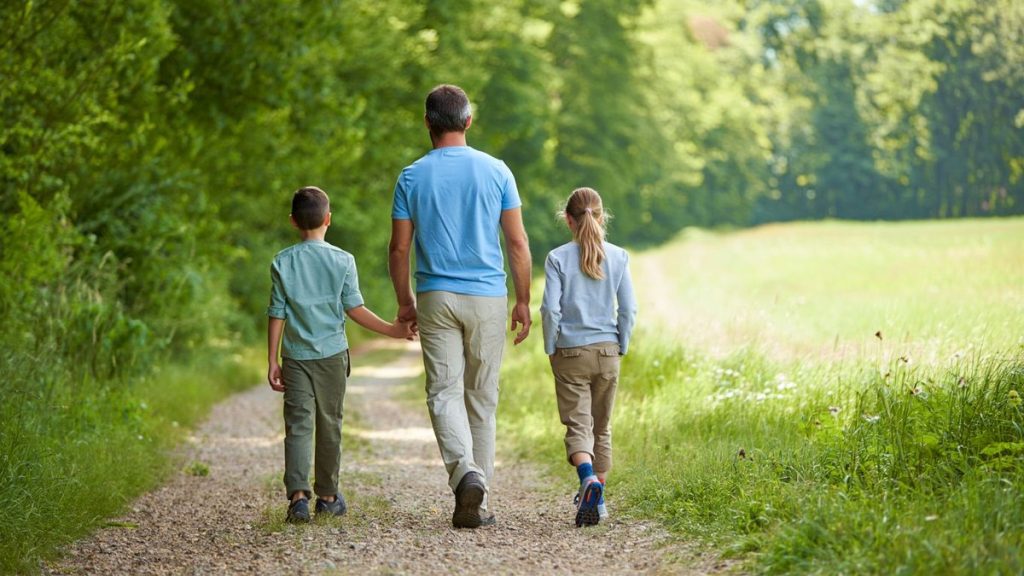 Famille marchant sur un sentier forestier naturel sans texte ni logo